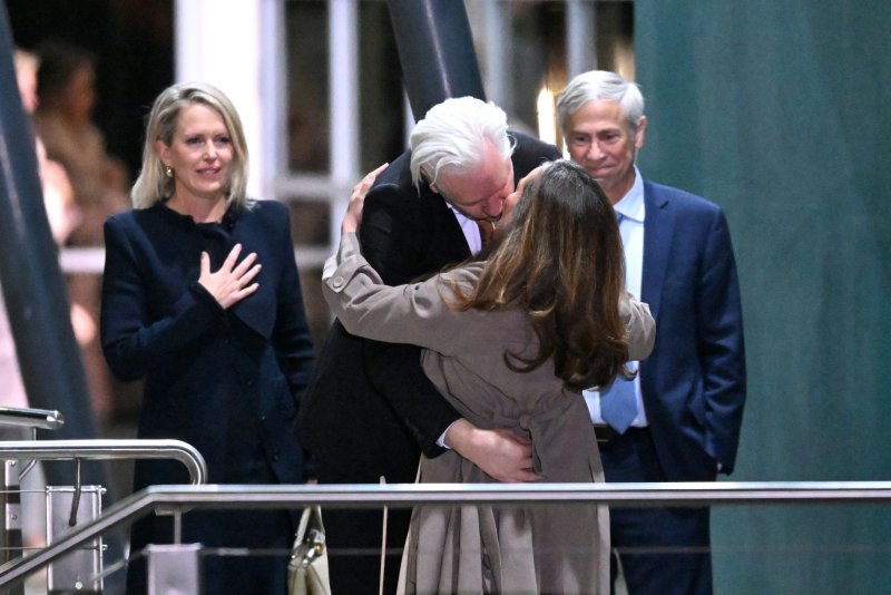 Julian Assange kisses his wife Stella Assange on Wednesday after stepping off a plane at Canberra Airport accompanied by his Australian and American legal counsel Jennifer Robinson (L) and Barry Pollack (R). Photo by Lukas Coch/EPA-EFE