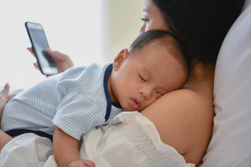 Mothers tend to speak less to infants when they're on their smartphones, a new study finds. Photo by Adobe Stock/HealthDay News