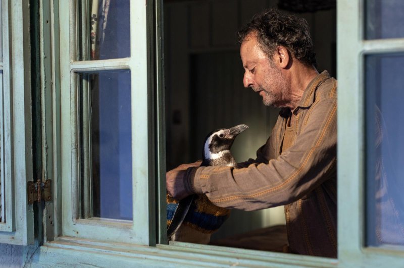 A Brazilian fisherman (Jean Reno) befriends a penguin in "My Penguin Friend." Photo courtesy of Roadside Attractions