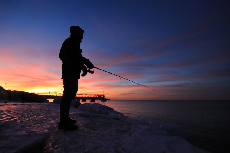 A man fishes on the frozen shoreline of Lake Erie as the sun sets in Cleveland, Ohio in 2022. NOAA issued a hazardous algae bloom for western Lake Erie on Thursday. Photo by Aaron Josefczyk/UPI